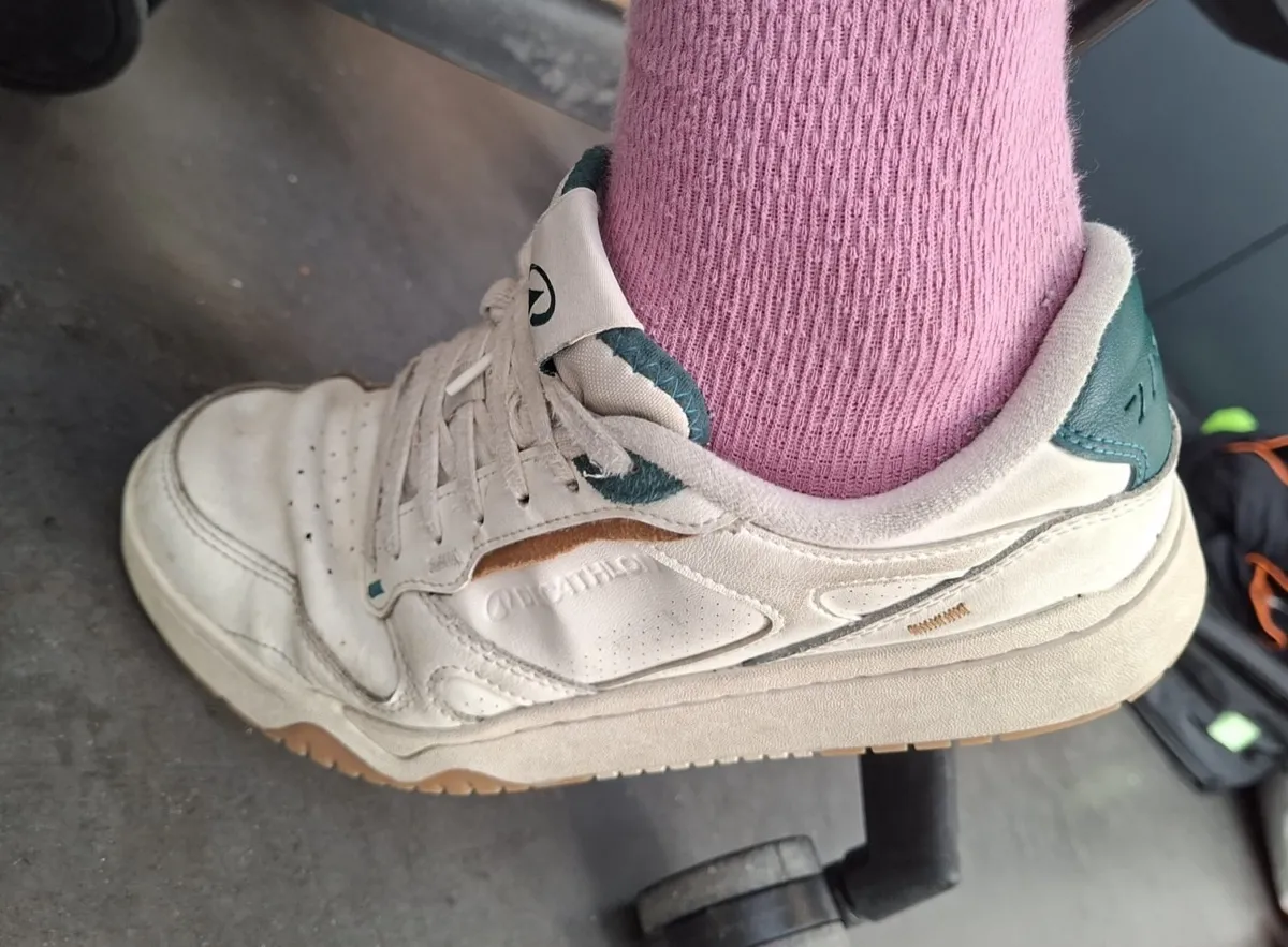 Le même sneaker de profil, sur un sol de parking